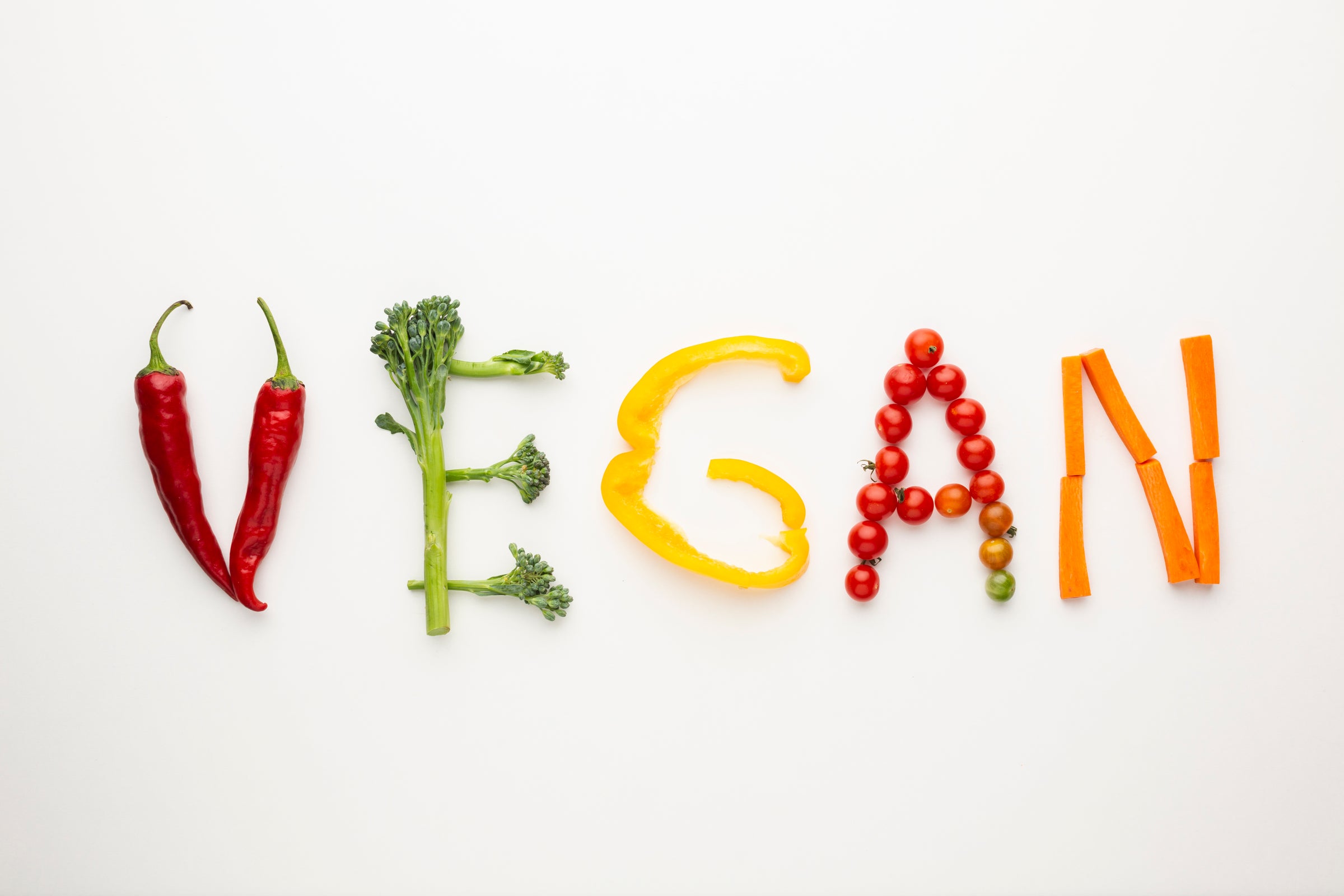 vegan letters made from fruits on white background