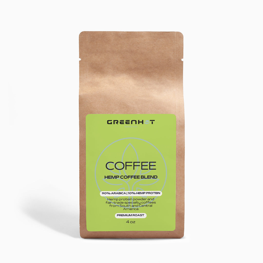 The brown paper bag labeled "GreenHat Organic Hemp Coffee Blend - Medium Roast 4oz" displays a green label with details, highlighting an organic hemp and Fair Trade coffee blend for a sustainable brew.