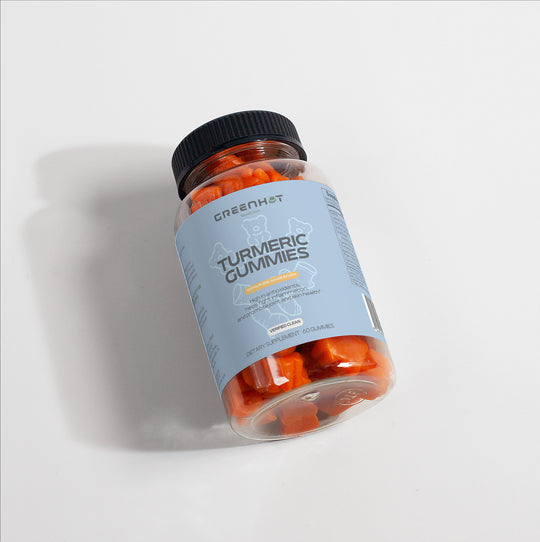 A clear plastic bottle labeled "GreenHat Turmeric Gummies - Immunity Accelerator" with orange gummy supplements inside, topped with a black cap, is placed against a white background. These delicious gummies are rich in curcumin, an antioxidant known for its numerous health benefits.