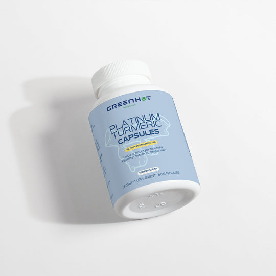 A white bottle labeled "GreenHat Platinum Turmeric - Immunity Accelerator" containing 60 capsules is placed on a white surface, promoting digestive health and joint pain relief.