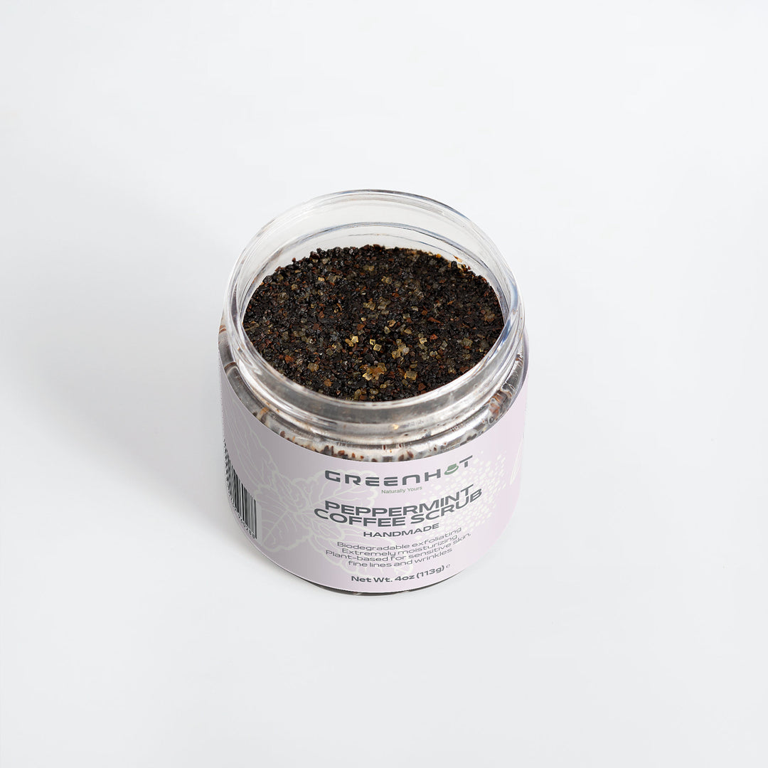 A jar of GreenHat Peppermint Coffee Scrub on a white background. The jar is open, revealing the scrub's texture and labeled "GreenHat" and "Peppermint Coffee Scrub," which offers effective exfoliation with antioxidant-rich coffee.