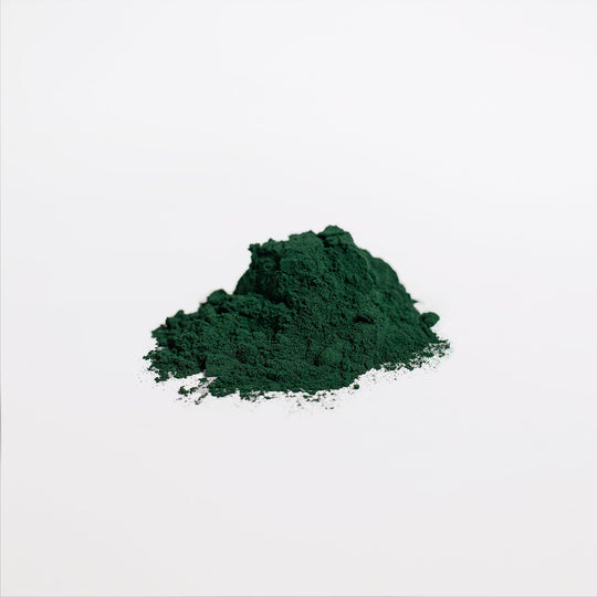 A small pile of GreenHat's Organic Spirulina Powder - Ocean's Best, known for its dense nutrient content and high protein, rests on a plain white background.