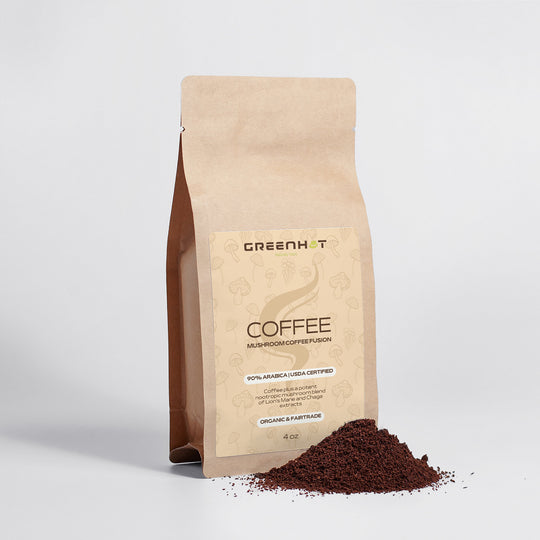 A brown paper bag labeled "GreenHat," featuring a blend of Mushroom Coffee Fusion - Lion’s Mane & Chaga 4oz, is displayed next to a small pile of the same ground coffee.