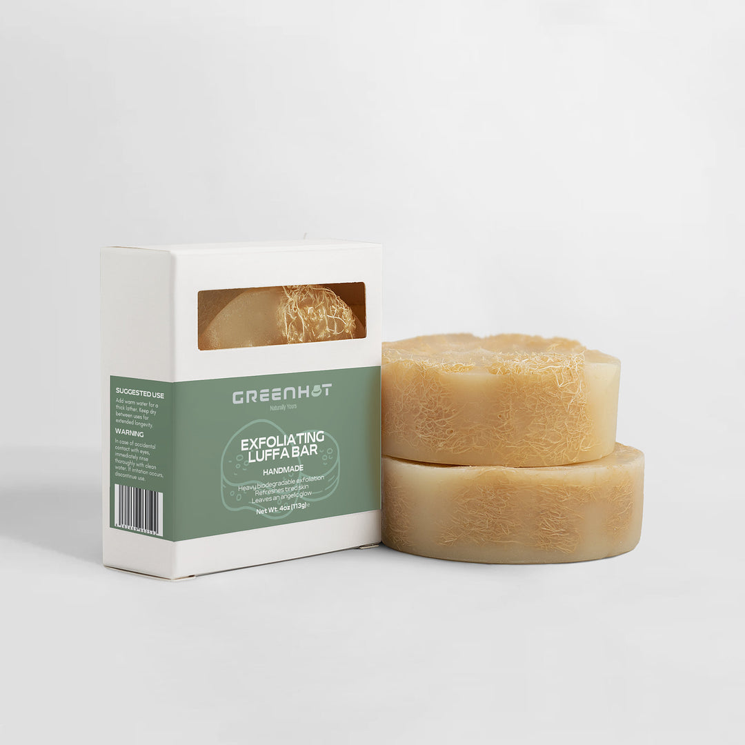 Two round Exfoliating Luffa Bars beside their packaging labeled "GreenHat Exfoliating Luffa Bar" on a white background, now prominently featuring biodegradable exfoliation.