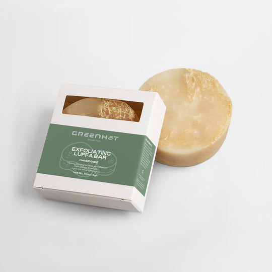 A bar of GreenHat exfoliating luffa soap next to its open packaging labeled "GreenHat handmade exfoliating luffa bar, natural skin care.