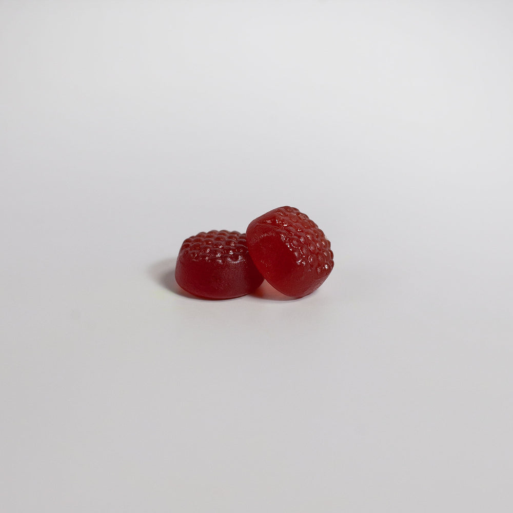 Two GreenHat elderberry and vitamin C gummies on a plain white background.