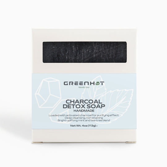A box of GreenHat Charcoal Detox Soap, displaying a sketch of a diamond and text highlighting its natural, handmade, deep cleansing properties. The background is plain white.