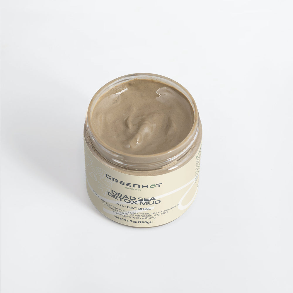 Open jar of GreenHat Dead Sea Detox Mud on a white background, showing its creamy, gray contents, ideal for natural skincare and skin rejuvenation.