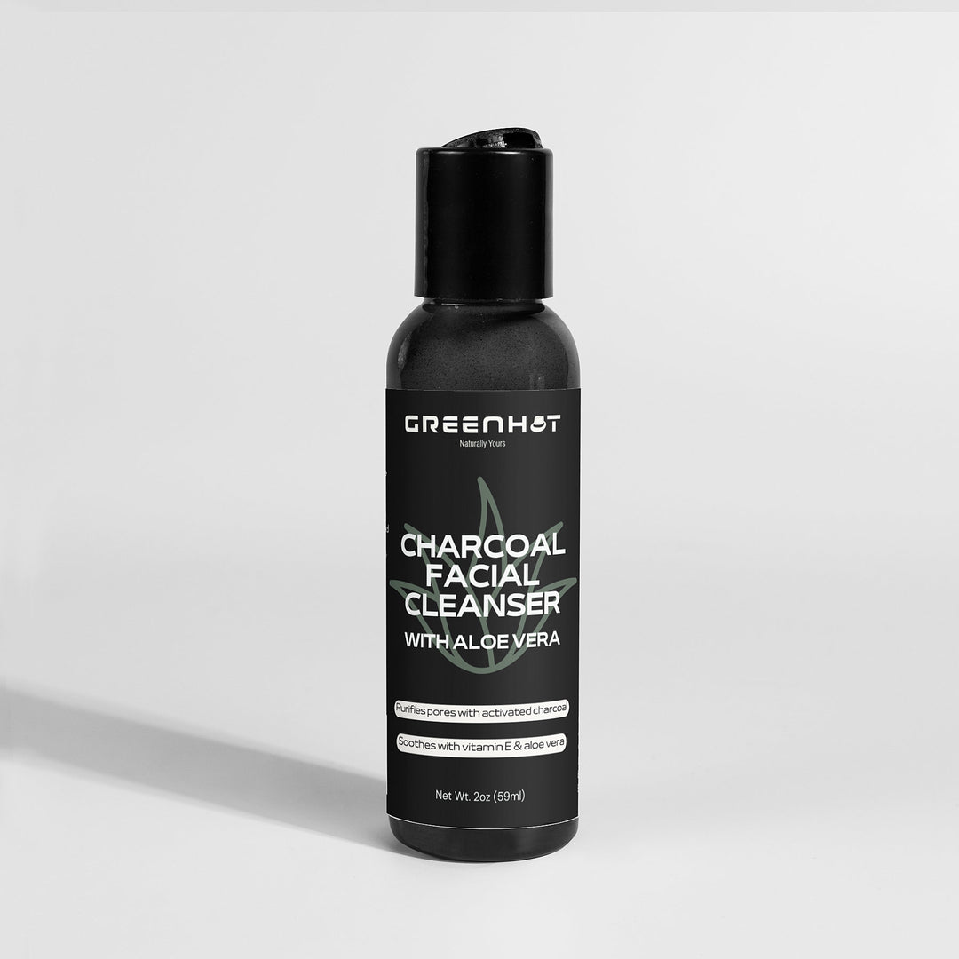 A 3oz bottle of GreenHat Charcoal Facial Cleanser is shown. The label highlights natural ingredients such as activated charcoal, vitamin E, and aloe vera, making it perfect for daily use.