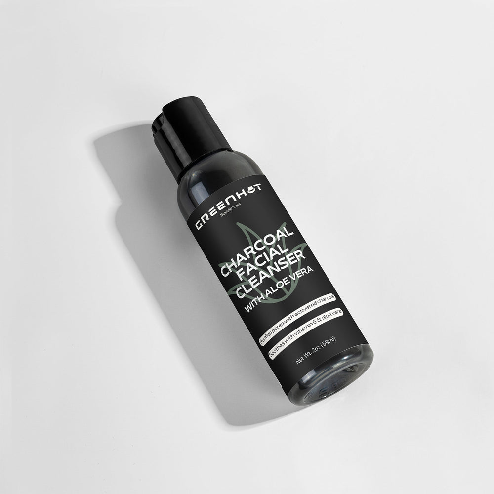 A bottle of GreenHat Charcoal Facial Cleanser with Aloe Vera, 7 fl oz, for daily use and made with natural ingredients, is displayed against a white background.