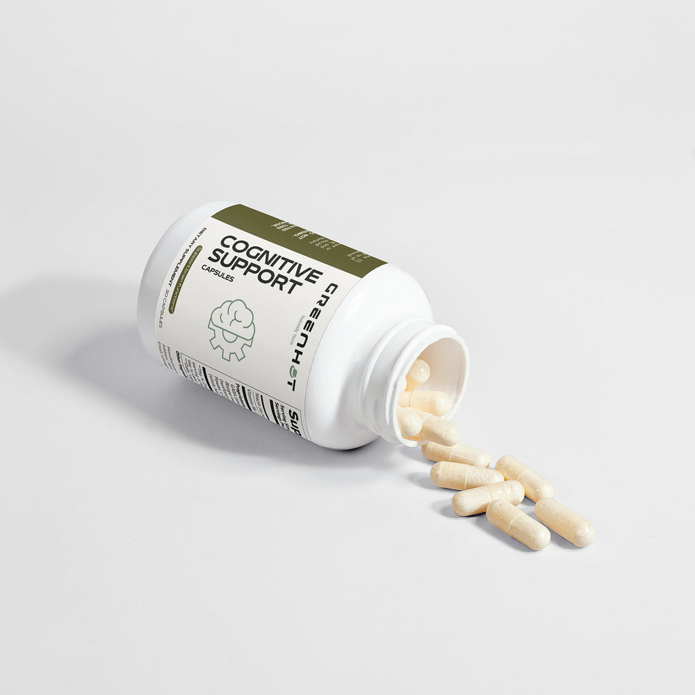 A white bottle labeled "Cognitive Support" lies on its side, with several beige capsules spilling out onto a plain surface. This cognitive enhancement supplement from GreenHat, made from natural ingredients, aims to promote mental clarity and support overall brain health.