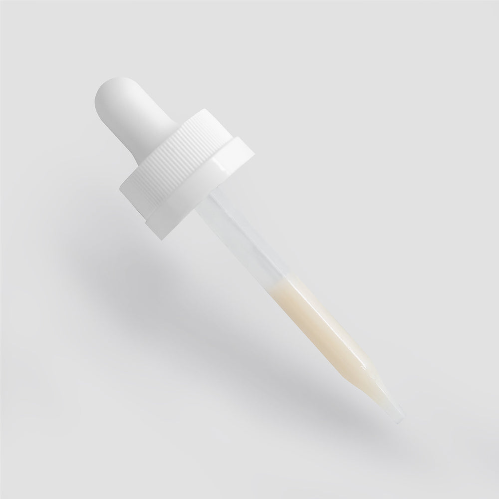 A white dropper filled with a beige Dark Spot Serum for Normal Skin by GreenHat, placed against a clean, white background.
