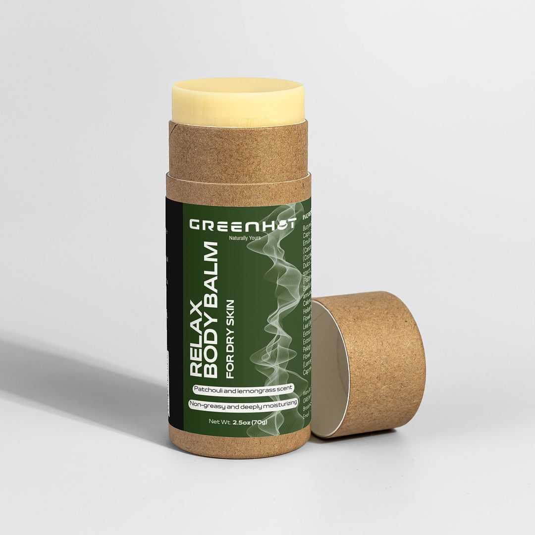 A cylindrical tube of "GreenHat Relax Body Balm" for dry skin with an open cap placed beside it. The label highlights patchouli and lemongrass scent, non-greasy, and deeply moisturizing properties, offering aromatherapy benefits as a revitalizing moisturizing treatment.