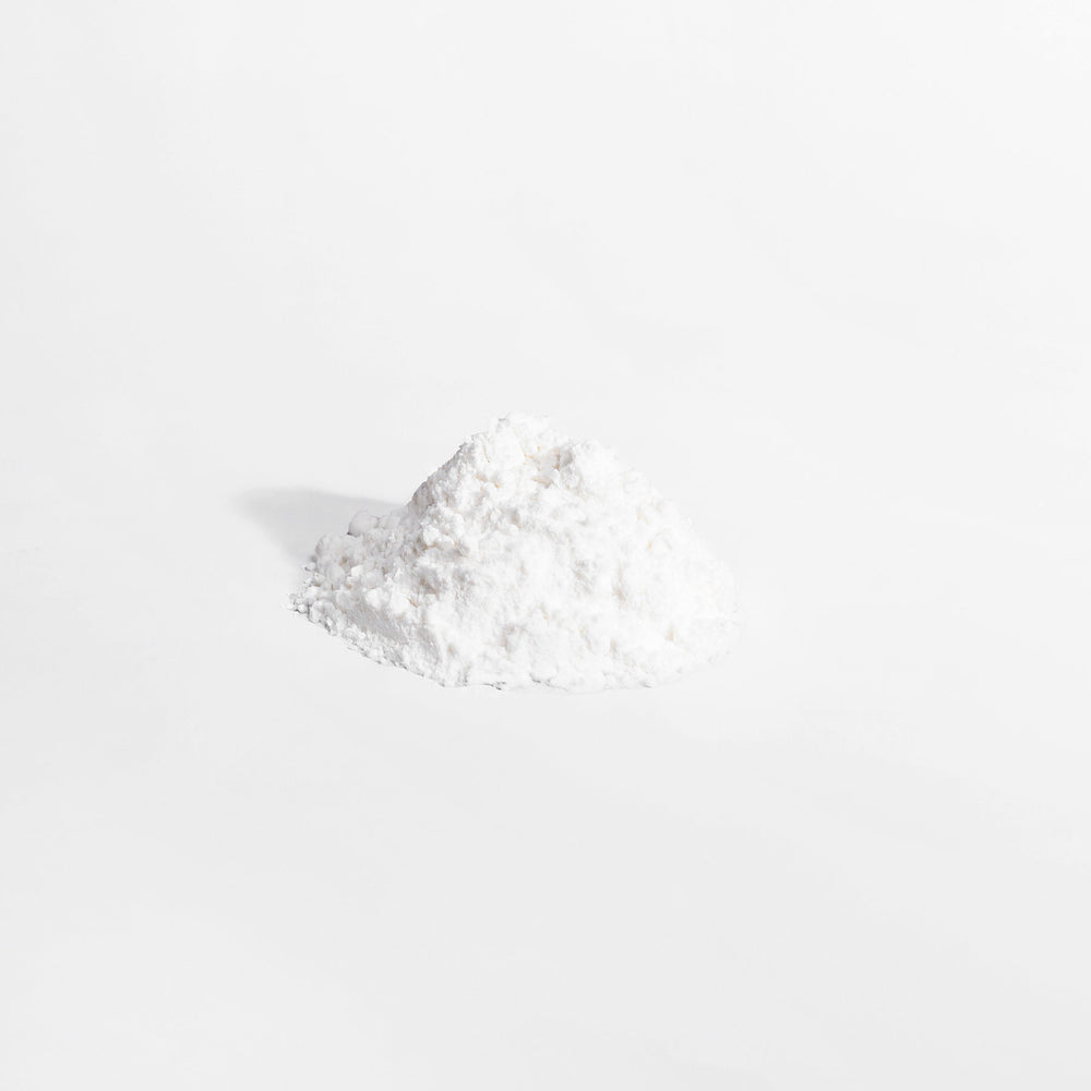 A small pile of GreenHat L-Glutamine Powder on a plain white background.
