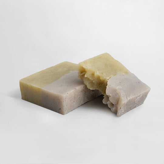 Two bars of GreenHat's Woodland Bliss Soap, one partially broken, on a plain white background.